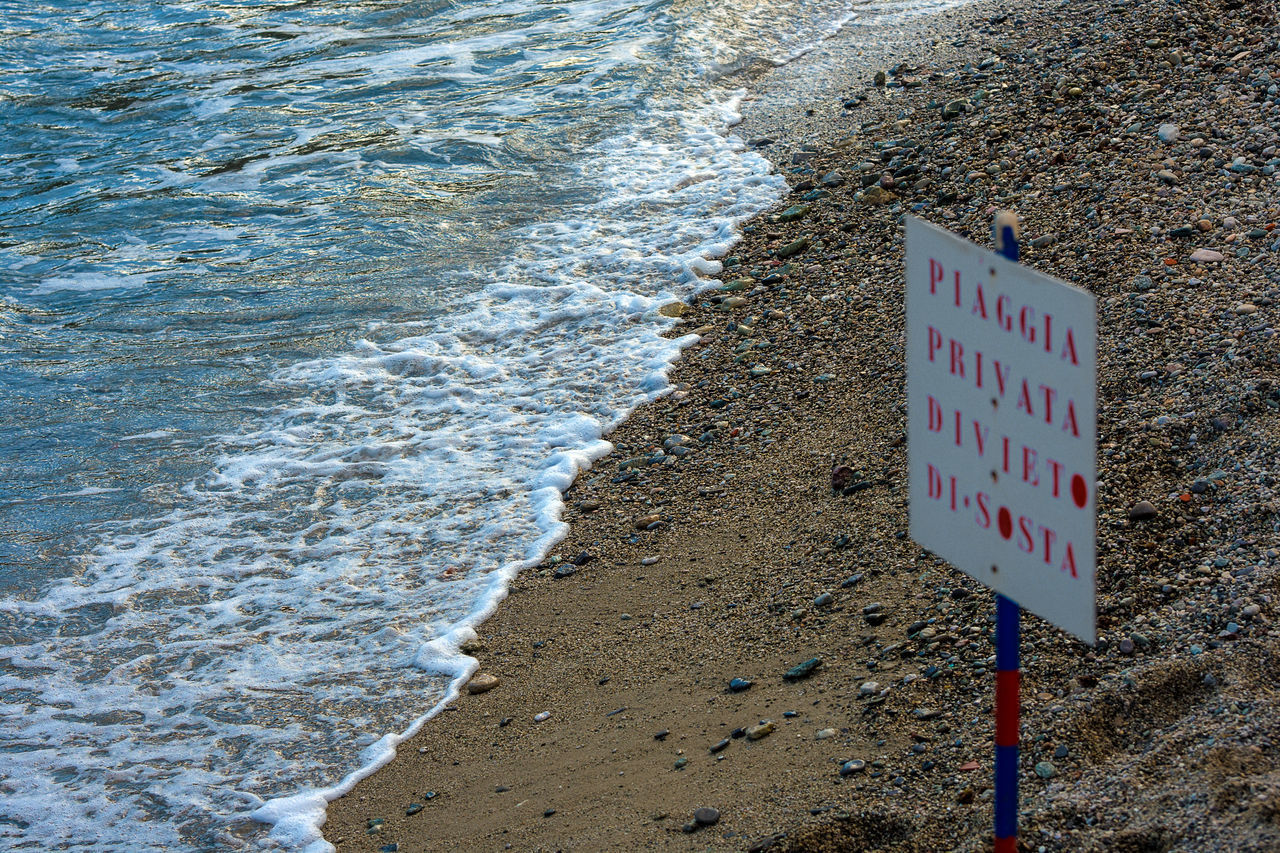 CLOSE-UP OF TEXT ON BEACH