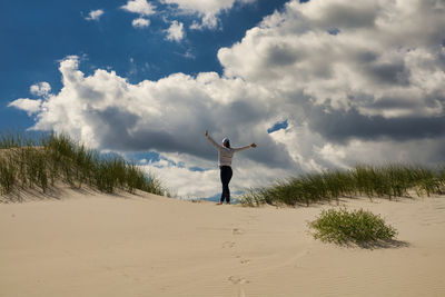 Full length of man standing on beach against sky