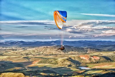 Kite flying over landscape against sky