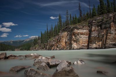 Scenic view of rocks on shore against sky