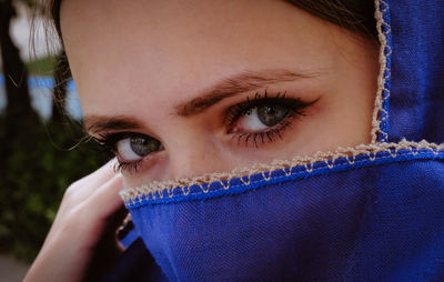 Close-up portrait of young woman with blue scarf