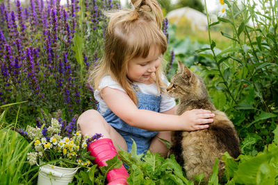 Full length of woman with cat against plants