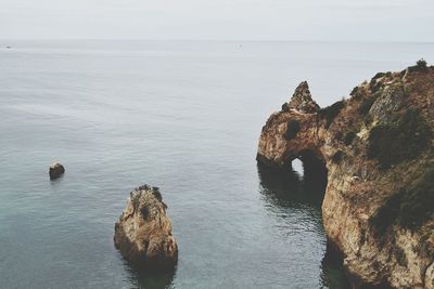 Rocks in sea against sky