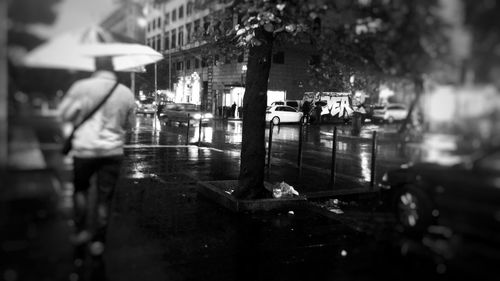 People walking on wet street at night