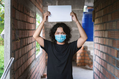 Portrait of man standing against wall