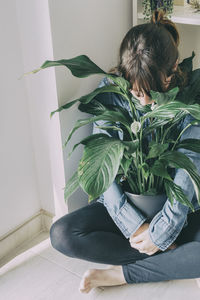 Woman holding potted plant at home