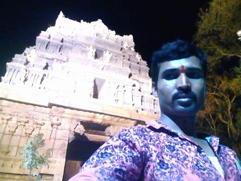 Low angle portrait of man against building