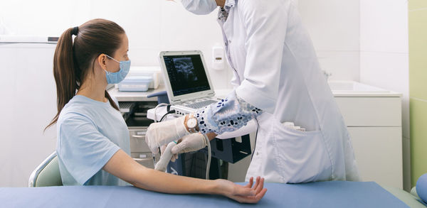 Doctor giving ultrasound therapy to patient in clinic