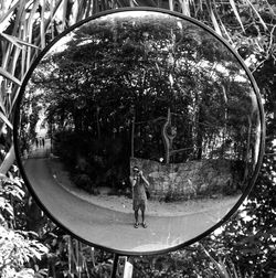 Reflection of man photographing on mirror