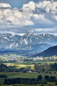 Scenic view of field and mountains against sky