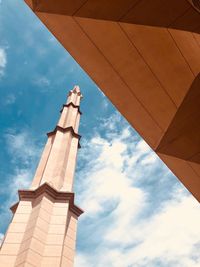 Low angle view of building against cloudy sky