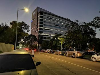 Cars on city street against sky