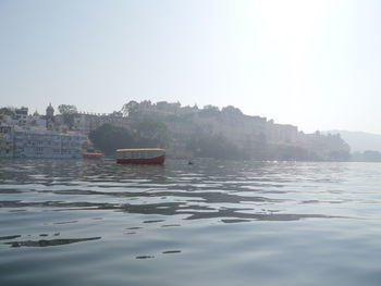 Boat floating on water against clear sky