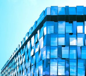 Low angle view of modern building against clear blue sky