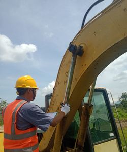 Low angle view of man working against sky