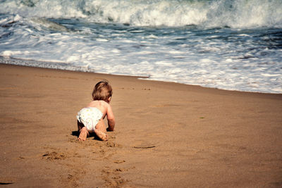 Full length of girl sitting on beach