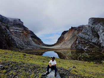 Woman on rock against sky