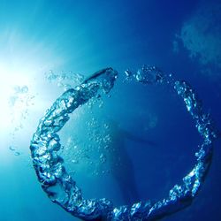 Close-up of bubbles with person swimming undersea