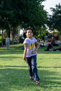 Full length of 6 year old girl running on grassy field