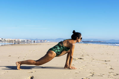 Yoga woman doing yoga pose on the beach for wellbeing health lifestyle.