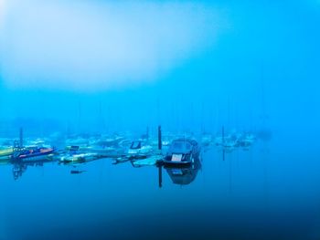 Boats in sea against blue sky