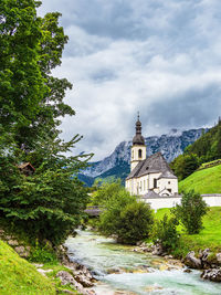 River amidst trees and buildings against sky