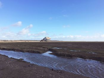 Scenic view of beach against blue sky