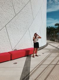 Side view of woman standing against building