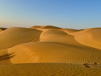 Scenic view of desert against clear blue sky