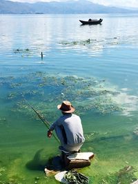 Rear view of man fishing in sea