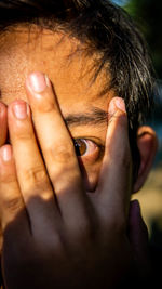 Close-up portrait of man covering face