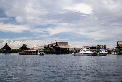 Scenic view of river by buildings against sky