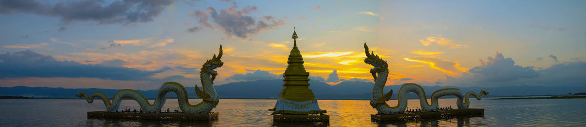 Traditional building against cloudy sky during sunset