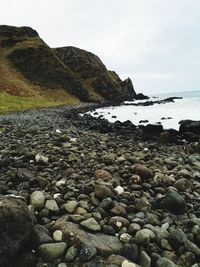 Rocks on beach against sky