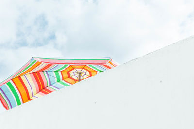 Low angle view of multi colored umbrella against sky