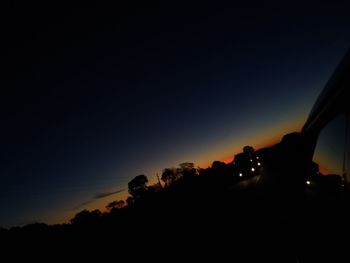 Silhouette trees against sky at night