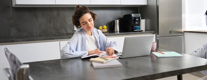 Young woman using laptop at table