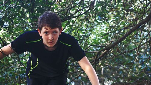 Portrait of teenage boy against tree
