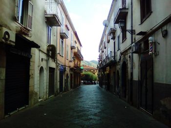 Street amidst houses against sky