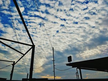 Low angle view of silhouette crane against sky