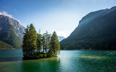 Scenic view of river by mountains against sky