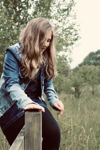 Full length of senior woman sitting on land