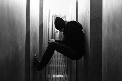 Full length of man balancing amidst wall over alley