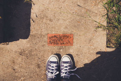 Low section of person standing by information sign outdoors