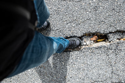 Low section of man standing on road