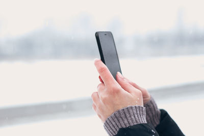 Close-up of hand holding mobile phone