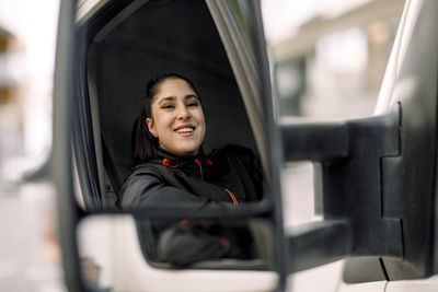 Portrait of smiling young delivery woman driving truck