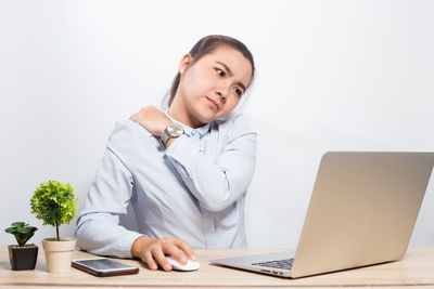 Woman using mobile phone while sitting on table