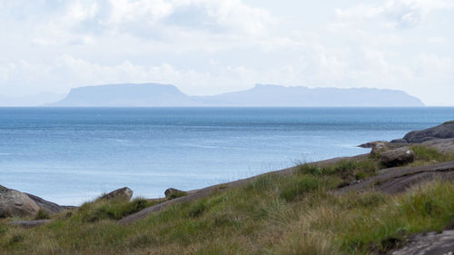 Scenic view of sea and mountains against sky