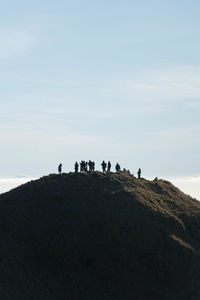 People on mountain road against sky